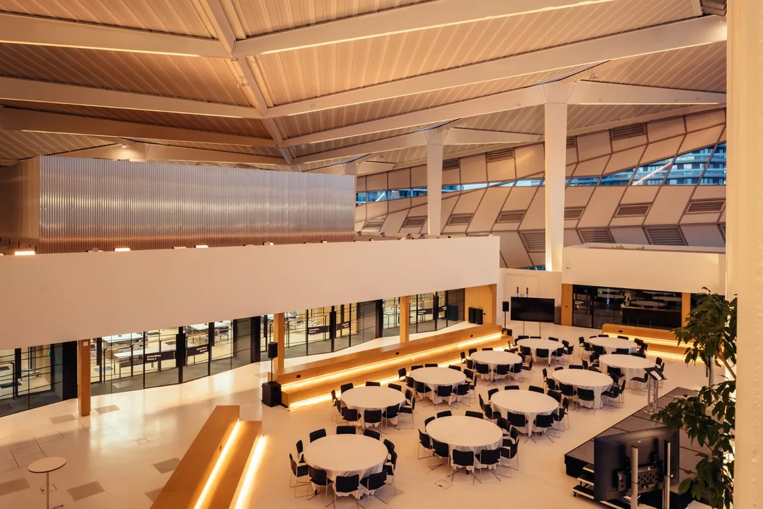 The main hall at City Hall, set with round tables under warm lighting